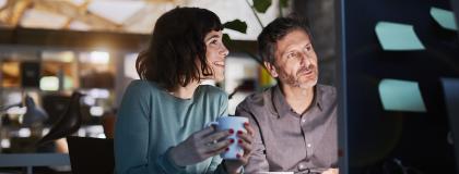 A man and woman sitting together looking at a computer screen.